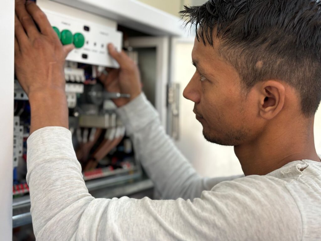 A man working on an electrical panel